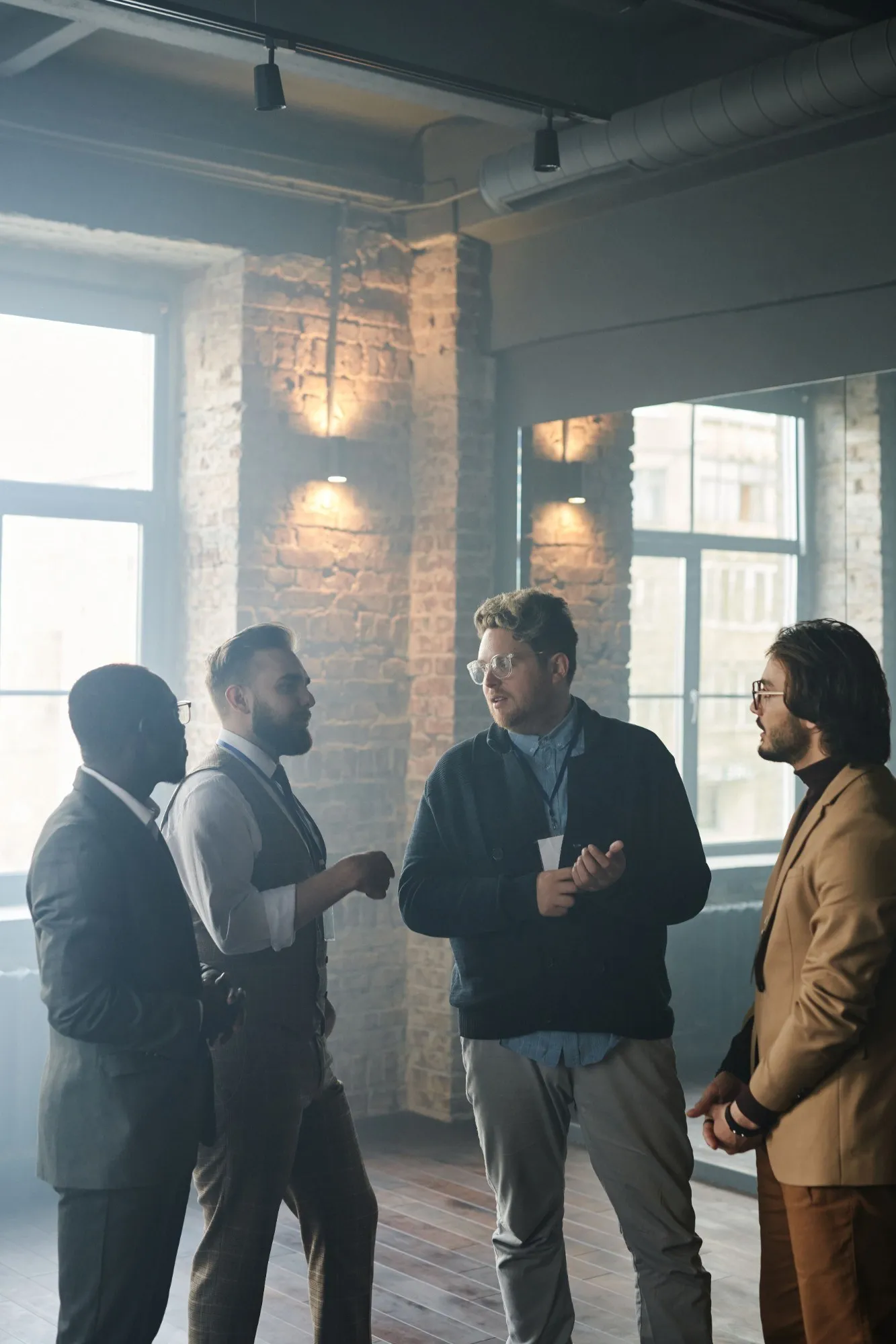 Members chatting in a warmly lit event space, wearing lanyards